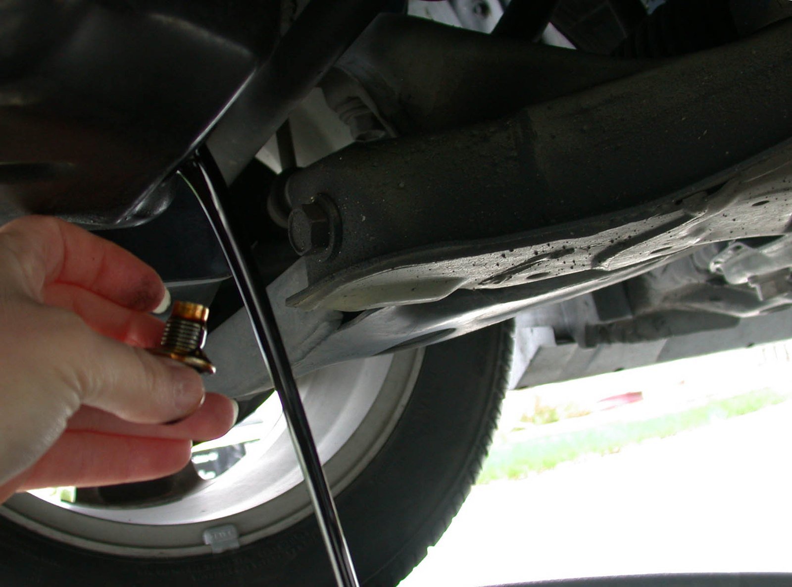 Oil change: the old oil draining out of the engine